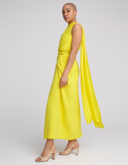 Actor Cush Jumbo in yellow top and skirt against grey background