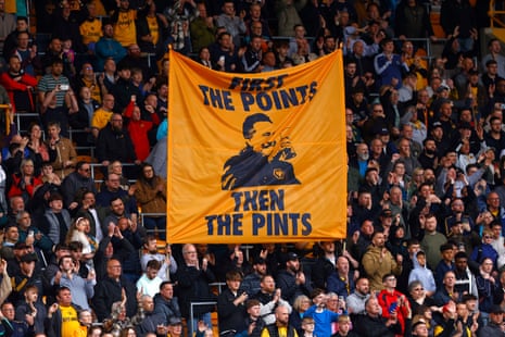 Fans of Wolves display a flag quoting manager Vitor Pereira's 'First the points then the pints' mantra during a match against Tottenham