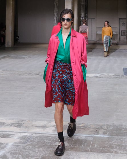 A model wears a pink coat, green shirt and patterned shorts at Dries van Noten recent show.