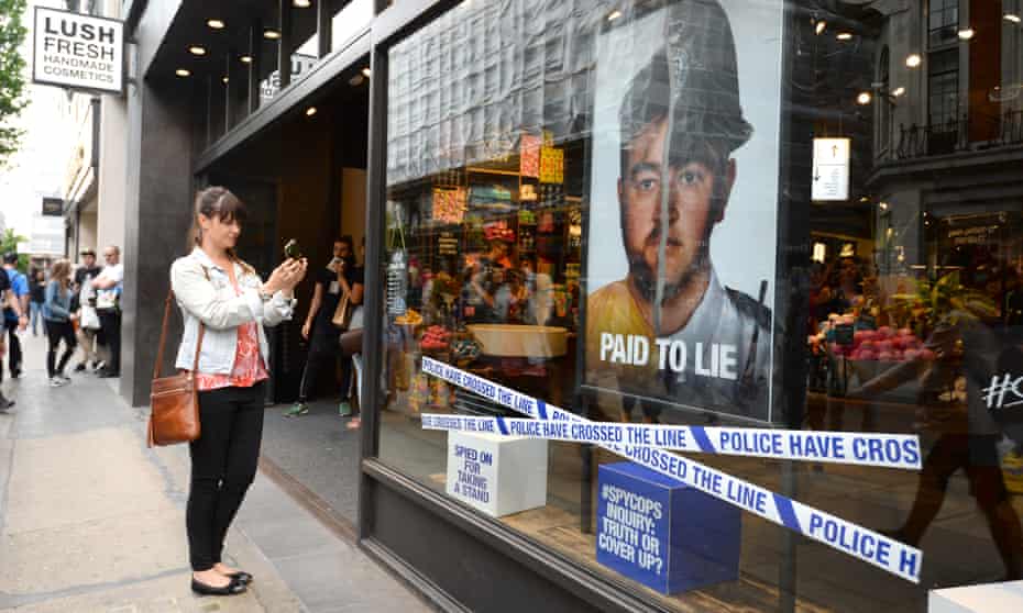 A Lush store with posters highlighting the misconduct of undercover police