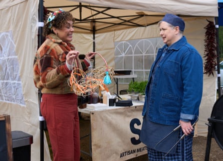 Fi smiles holding a woven basket while Della, in a denim jacket and cap, looks on