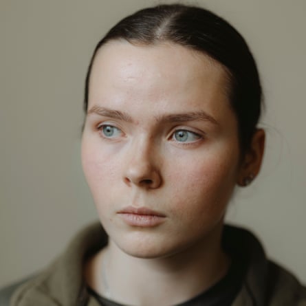 she has very pale skin and blue-grey eyes, and straight, dark hair tied back. She looks serious and sombre.