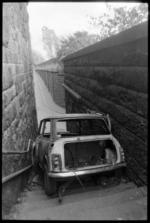 Burnt-out Mini stuck down the steps of the former Scotswood railway station, Newcastle upon Tyne, 1990