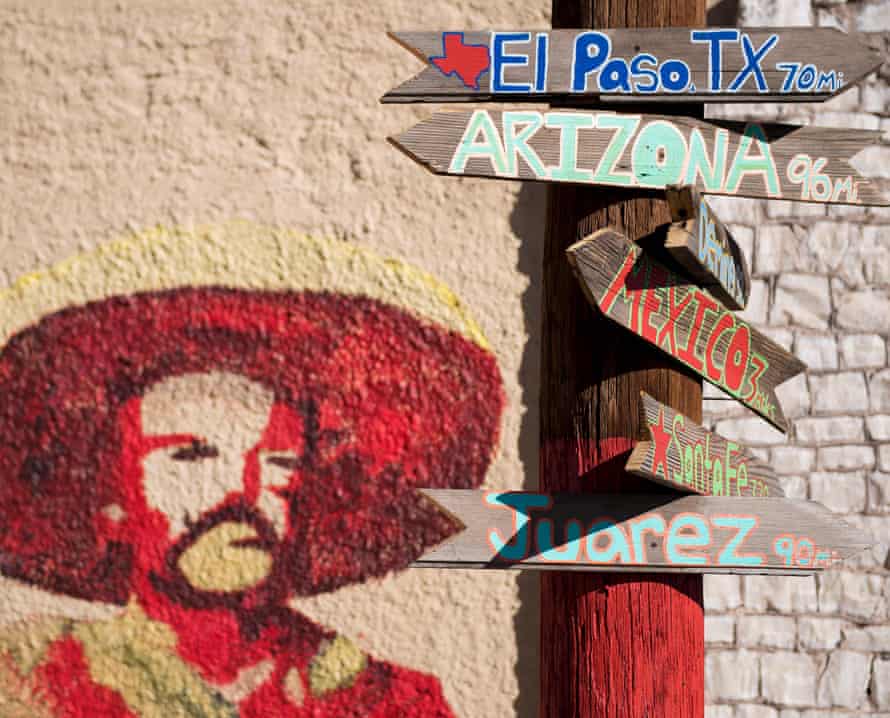 Signs telling the miles to different cities stands next to a mural of Mexican revolutionary leader Pancho Villa in Columbus, New Mexico