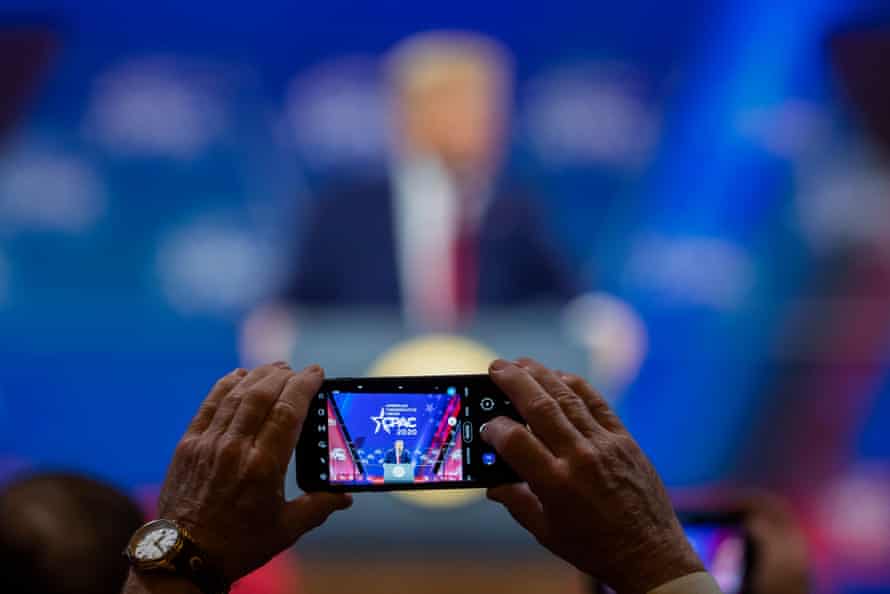 A person takes a photo as Donald Trump speaks during CPAC in Maryland on 29 February 2020.