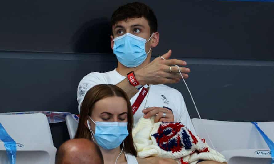 Tom Daley knits his GB Olympic sweater while watching men's diving at the Tokyo Olympics.