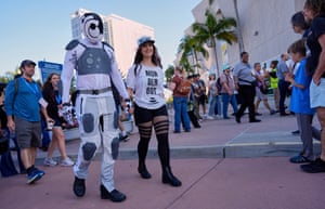 Chris Lane and his wife Shannon walk holding hands, with Chris dressed as Murderbot