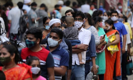 People wait in a line to enter a supermarket in Mumbai, India, on 4 April 2021. India on Monday reported a national record 100,000 new coronavirus cases in 24 hours. 