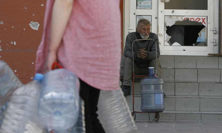 A man waits to get water in Mariupol.
