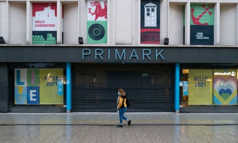 A woman walks past a closed Primark store in Cardiff.