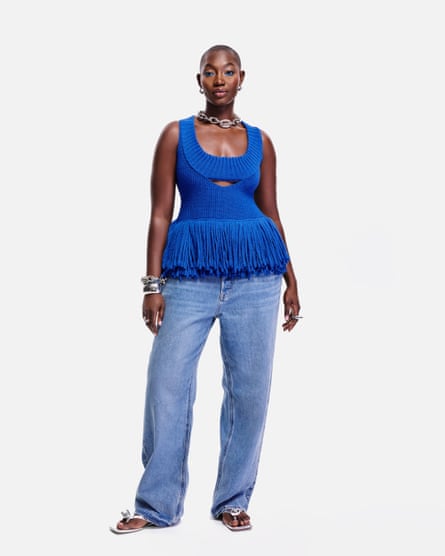 A model wearing a blue tank top and jeans