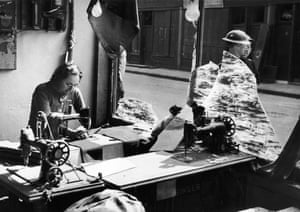 Mrs Marsh works amongst the broken glass of a tailor’s shop after an air raid on the East End of London during the Blitz, 1940