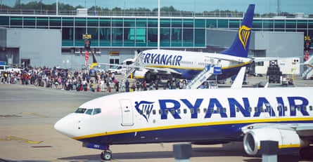 Pasażerowie ustawiają się w kolejce do samolotów Ryanair na lotnisku Stansted w lipcu 2022 r