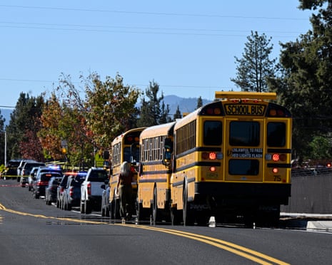 School buses and police vehicles line a road outside Silver Rail Elementary after a shooting