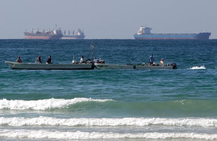 Fishers work in front of oil tankers south of the strait of Hormuz