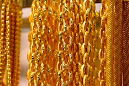Strings of shiny gold necklaces hanging next to each other