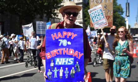 A man with a birthday placard as thousands of people march to mark 70 years of the NHS