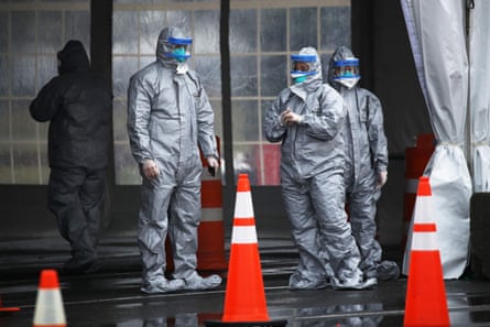 Workers in protective gear operate a drive-through mobile testing center in New Rochelle, New York.