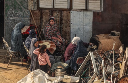 Palestinian women make traditional unleavened bread on an open fire on the roof of their house in Rafah