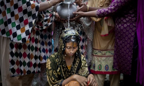 A 15-year-old girl is bathed on the day of her wedding to a man more than twice her age in Manikganj, Bangladesh