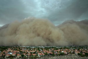A huge dense brown cloud of dust about to engulf a residential area