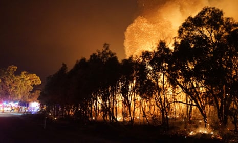Firefighters watch as a blaze moves through Deepwater National Park in Queensland