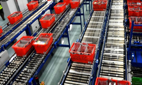 Conveyer belts transport crates filled with packed bags inside the Ocado customer fulfilment centre in Hatfield