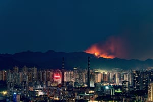 Smoke and flames rise into the sky during a mountain forest fire in Chongqing