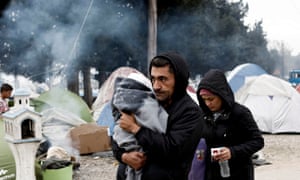 A man carries his baby at the Idomeni refugee camp near the Greece-Macedonia border.