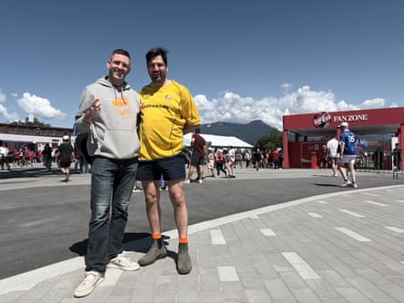 Two men standing on a street in Vancouver among Socceroos fans