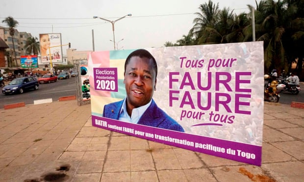 Motorists drive past a campaign billboard in Lomé bearing the image of President Faure Gnassingbé