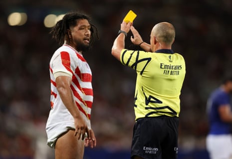 Referee Jaco Peyper shows a yellow card to Shota Horie.