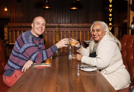 Fred and Maxine clinking glasses across a restaurant table
