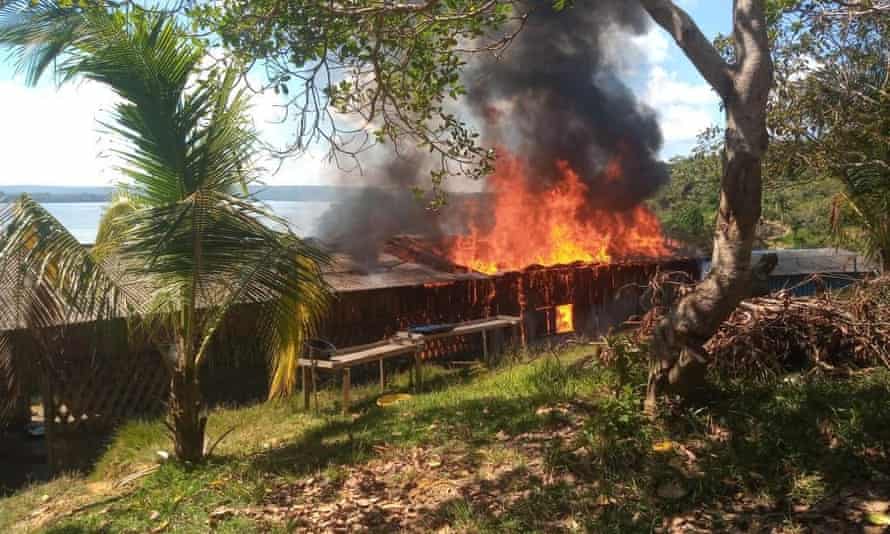 Houses burn in a Munduruku village after an attack by wildcat miners in the Brazilian state of Roraima.