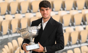 Carlos Alcaraz poses with the French Open men's singles trophy.