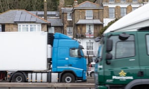 An English flag hangs from the balcony of a house in Dover, as cross-Channel lorries pass.