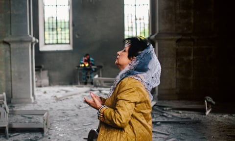 A woman prays inside the Cathedral of the Holy Saviour, in the town of Shusha, that got destroyed after being hit by two missiles.