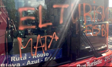Four hooded men attacked a city tourist bus in Barcelona and spray-painted ‘Tourism kills neighbourhoods’ on the windscreen as they shouted abuse at the passengers.