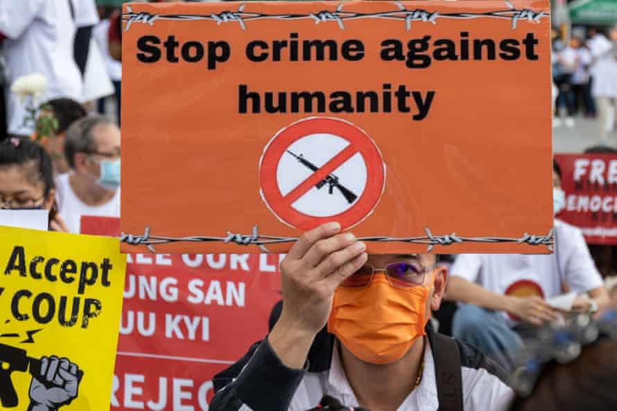 A man holding a sign reading 'Stop crime against humanity' at a protest against the Myanmar coup in Taipei, Taiwan