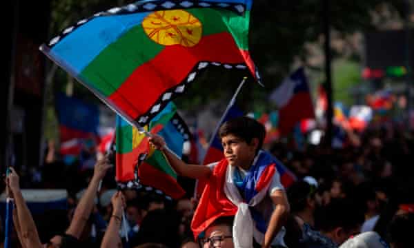 et barn bølger en mapuche indfødte flag under en protest march i Santiago på fredag.