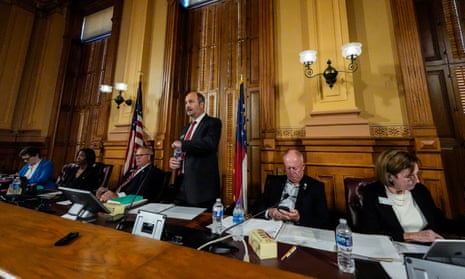 people in suits sit and stand at a dais