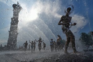 Children running through a fountain during a heatwave