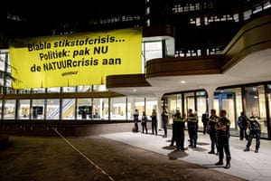 Greenpeace activists unveil a banner on the temporary building of the House of Representatives in The Hague, the Netherlands