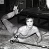 Iggy Pop lies on the stage, microphone in hand