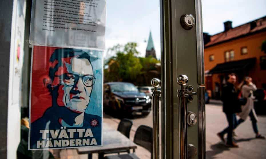 A portrait of Sweden’s chief epidemiologist, Anders Tegnell, hangs below a sign telling people to wash their hands at a restaurant in Stockholm.
