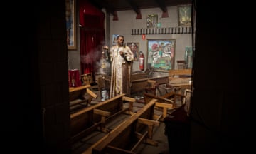 Preist Aragachew Semo blesses the church after floodwaters ruined the local Ethiopian Orthordox Church in Maribynong, Melbourne. Photograph by Christopher Hopkins for The Guardian