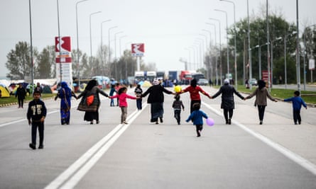 Migrants hold hands as they block the highway near the town of Polykastro in northern Greece in protest at the closure of the border with Macedonia.