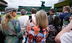 Spectators wait to watch a Wimbledon match.