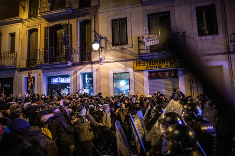A group of protesters face off against a line of riot police in Barcelona on Saturday night