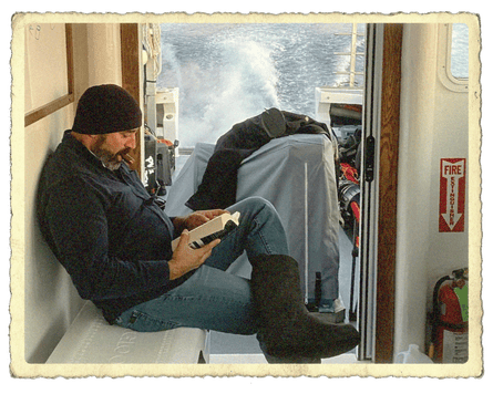 A man reads a book on a boat